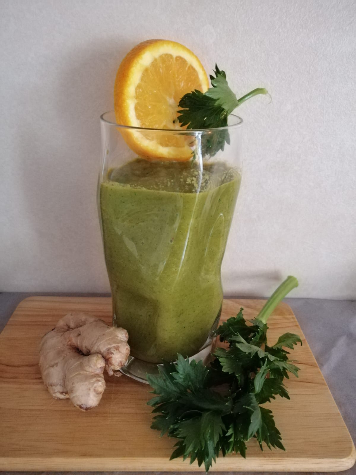 Grüner Smoothie aus Sellerieblättern, Karotten, Orangen, Apfel und Ingwer